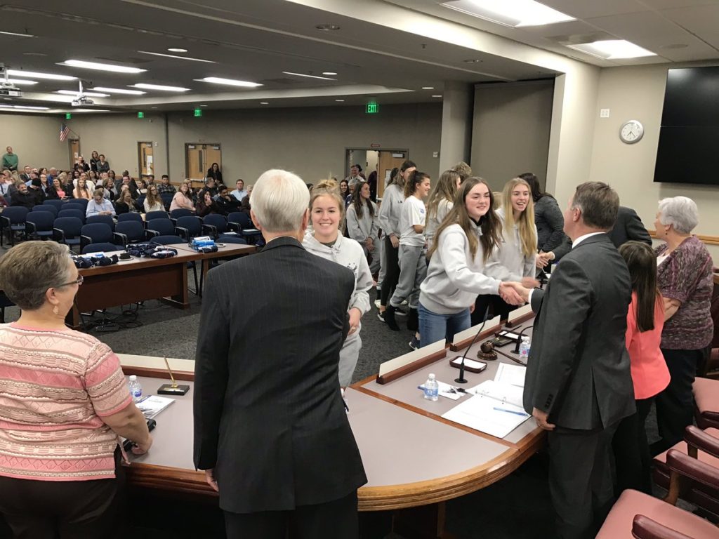 Soccer players shake hands with board members